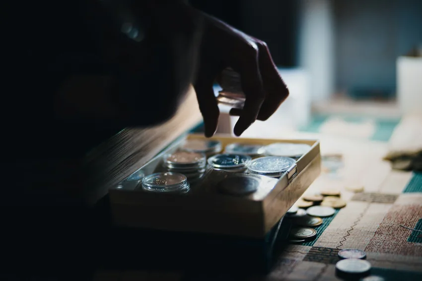 Hands sorting a table full of coins