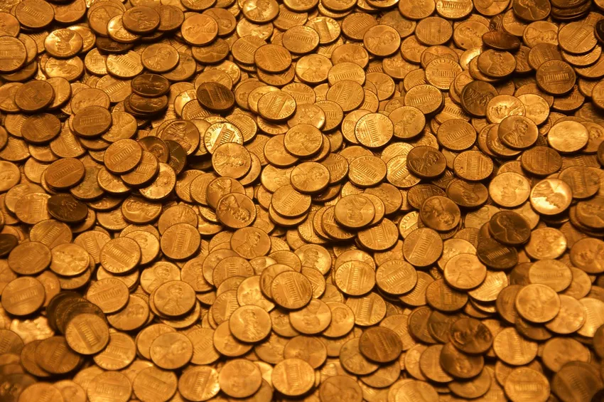 Old copper coins spread on a wooden tabletop